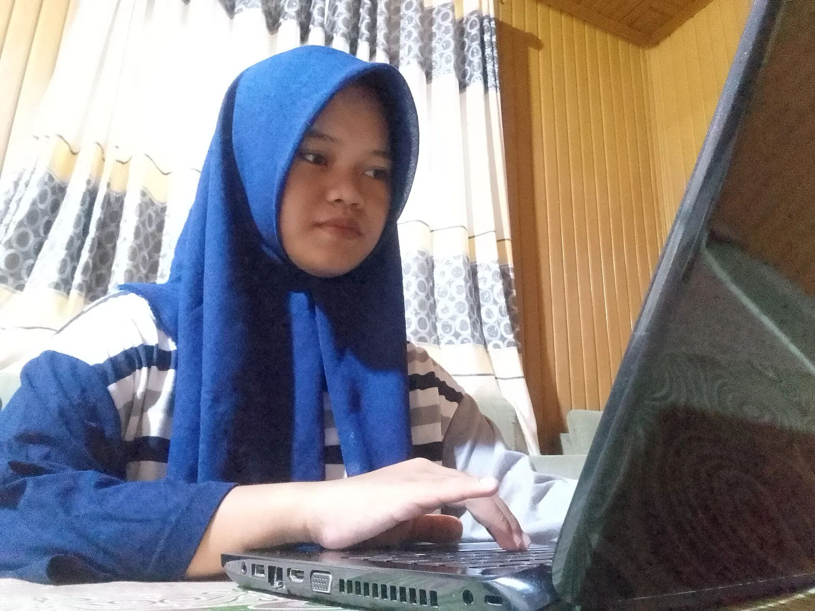 Mahasiswi menyunting video di laptop